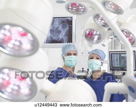 Stock Image - Nurses in operating theatre. Fotosearch