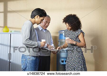 Picture - Office workers standing by water cooler. Fotosearch