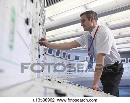Stock Image - Operator working in control room. Fotosearch