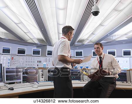 Operators talking in control room View Large Photo Image Stock Image - Operators talking in control room. Fotosearch