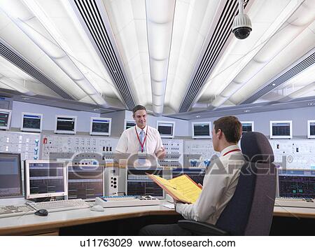 Stock Photo - Operators talking in control room. Fotosearch