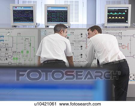 Stock Image - Operators working in control room. Fotosearch