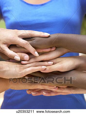 Stock Image - Pairs of hands on top of each others. Fotosearch