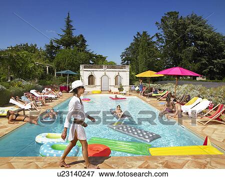 Stock Photo - People enjoying summer around the pool. Fotosearch