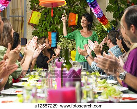 "People sitting at table, celebrating" View Large Photo Image Stock Photo - "People sitting at table, celebrating". Fotosearch