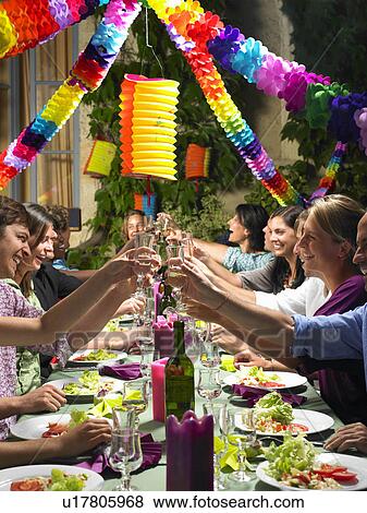 "People sitting at table, celebrating" View Large Photo Image Stock Photo - "People sitting at table, celebrating". Fotosearch
