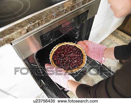 Stock Photography - Pie coming out of oven. Fotosearch