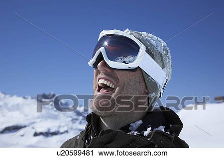 Stock Image - Portrait of man wearing ski goggles. Fotosearch