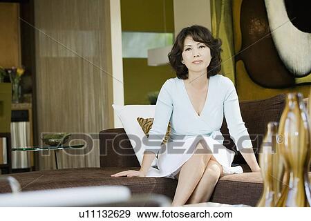 Stock Photo - Portrait of mature woman in living room. Fotosearch