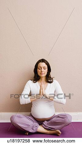 Stock Photo - Pregnant woman doing yoga. Fotosearch