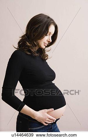 Pregnant woman holding her belly View Large Photo Image Stock Photo - Pregnant woman holding her belly. Fotosearch