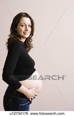 Pregnant woman holding her belly View Large Photo Image Stock Photograph - Pregnant woman holding her belly. Fotosearch
