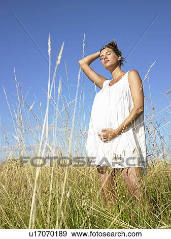 Pregnant woman in a field View Large Photo Image Stock Photo - Pregnant woman in a field. Fotosearch