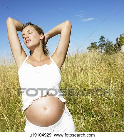 Pregnant woman in a field View Large Photo Image Stock Photo - Pregnant woman in a field. Fotosearch