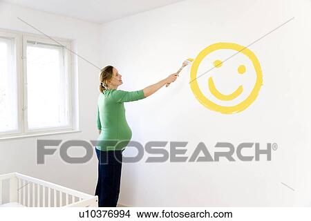 Pregnant woman painting nursery View Large Photo Image Picture - Pregnant woman painting nursery. Fotosearch