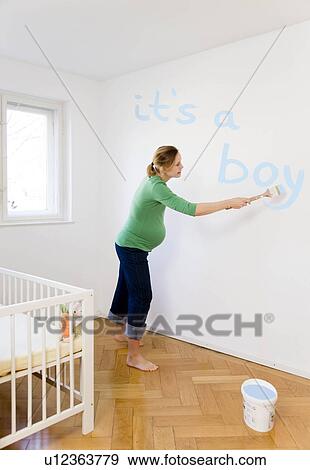 Pregnant woman painting nursery View Large Photo Image Stock Photo - Pregnant woman painting nursery. Fotosearch