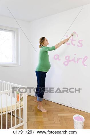 Stock Photo - Pregnant woman painting nursery. Fotosearch