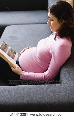 Stock Image - Pregnant woman reading a book. Fotosearch