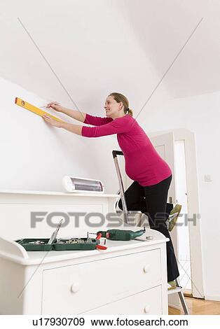 Stock Photo - Pregnant woman with level and tools. Fotosearch