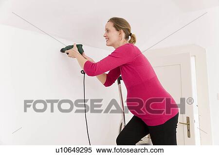 Stock Photography - Pregnant woman with power drill. Fotosearch