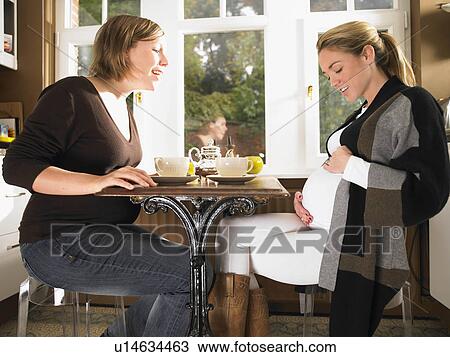 Stock Image - Pregnant women having tea. Fotosearch