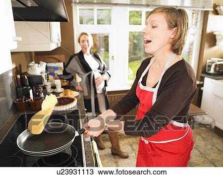 Stock Image - Pregnant women making pancakes. Fotosearch