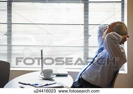 Stock Image - Senior businessman relaxing in cafe. Fotosearch