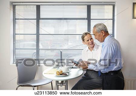 Stock Image - Senior co-workers having casual meeting. Fotosearch