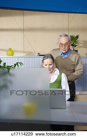 Stock Photo - Senior man and woman by office desk. Fotosearch