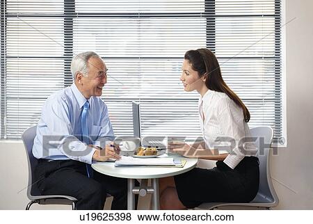 Stock Photo - Senior man and woman working in cafe. Fotosearch