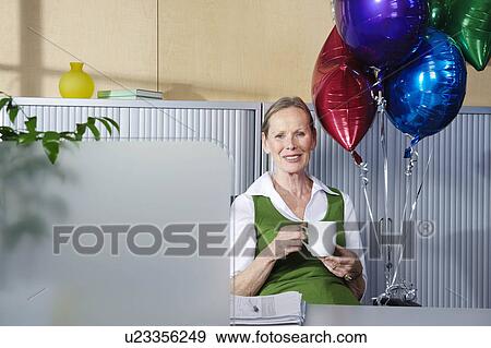Senior woman with balloons at desk View Large Photo Image Stock Photo - Senior woman with balloons at desk. Fotosearch