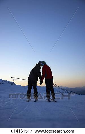 Stock Photo - Skiers kissing on top of mountain. Fotosearch