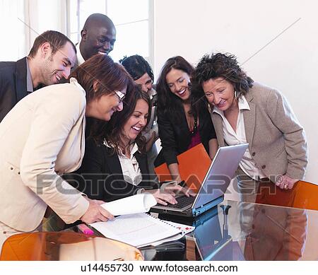 Stock Image - Smiling co-workers in office. Fotosearch