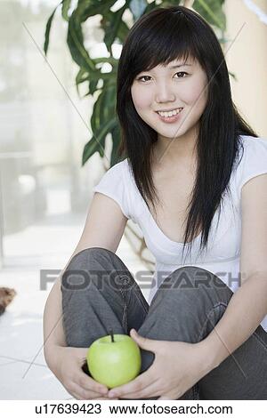Smiling teen holding apple View Large Photo Image Stock Image - Smiling teen holding apple. Fotosearch