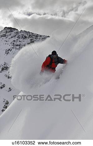 Stock Image - Snowboarder riding in deep snow. Fotosearch