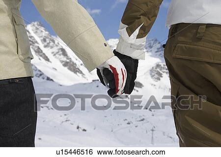 Stock Photograph - Snowboarders holding hands. Fotosearch