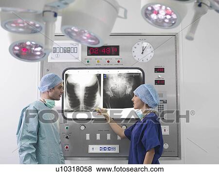 Stock Photo - Surgeon and nurse discussing x-rays. Fotosearch
