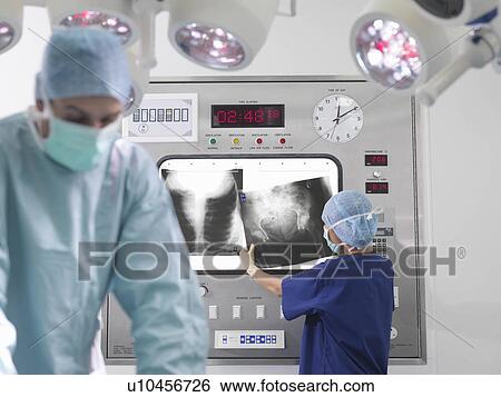 Stock Photograph - Surgeon and nurse with x-rays. Fotosearch