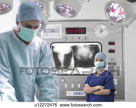Stock Photograph - Surgeon and nurse with x-rays. Fotosearch