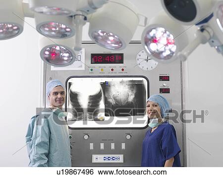 Stock Photograph - Surgeon and nurse with x-rays. Fotosearch