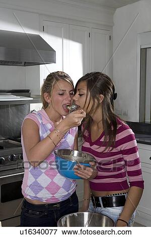 Stock Photo - Teen girls taste cake dough. Fotosearch