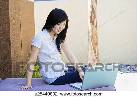 Teen relaxing outside working on laptop View Large Photo Image Stock Image - Teen relaxing outside working on laptop. Fotosearch