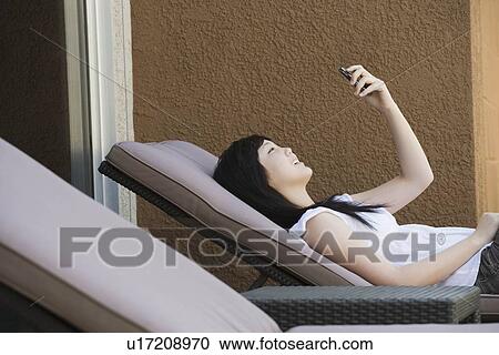 Stock Image - "Teen relaxing, reading text message". Fotosearch