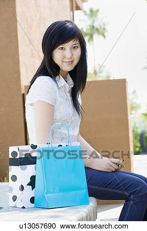 Stock Image - Teen with shopping bags and mobile phone. Fotosearch