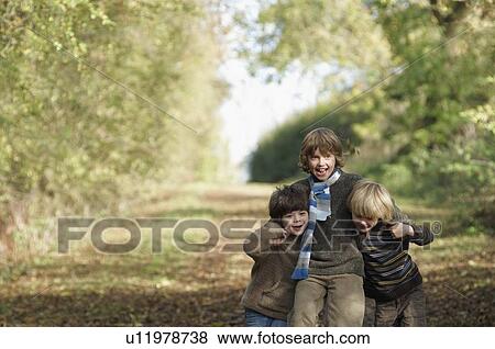 Stock Photo - Three boys walking on country lane. Fotosearch