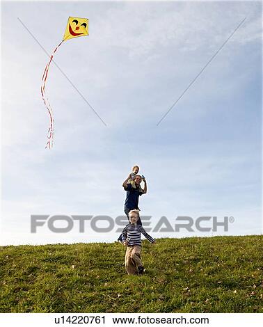 Two Boys and father fly a Kite View Large Photo Image Stock Image - Two Boys and father fly a Kite. Fotosearch