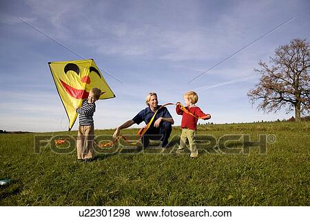 Two Boys and father put together a Kite View Large Photo Image Stock Photo - Two Boys and father put together a Kite. Fotosearch