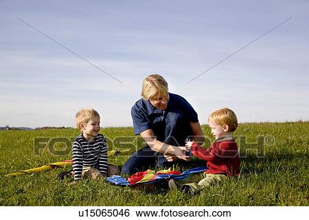 Two Boys and father put together a Kite View Large Photo Image Stock Photograph - Two Boys and father put together a Kite. Fotosearch