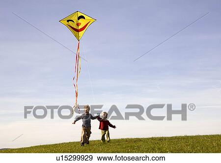 Stock Photo - Two Boys fly a Kite. Fotosearch