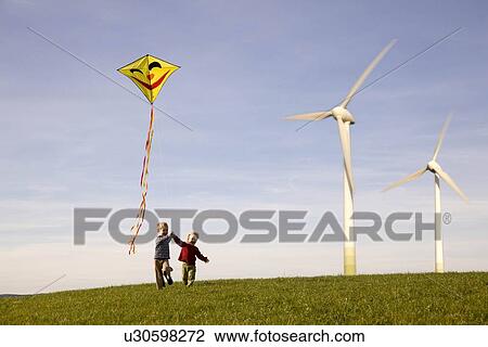 Two Boys Flying Kite at Wind Turbines View Large Photo Image Stock Image - Two Boys Flying Kite at Wind Turbines. Fotosearch